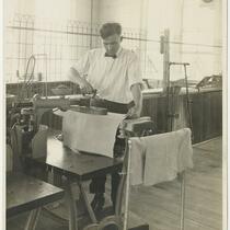 Frank Bursik pressing canvas at a Joseph & Feiss Co. facility