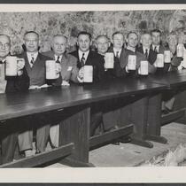 Unidentified group of men seated in rathskaller and holding beer steins